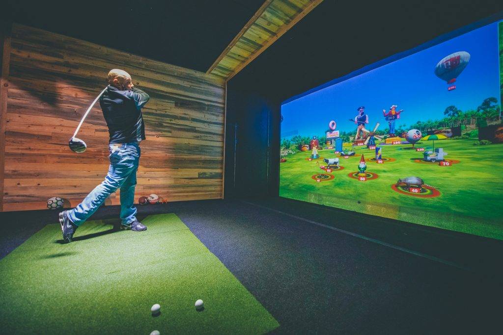 Playing Golf on sports simulator at Surge Entertainment