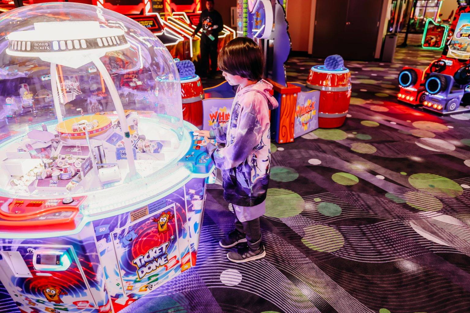 Child playing an arcade ticket game during a field trip.